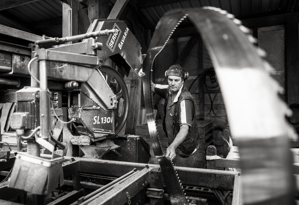 A man working on a saw machine