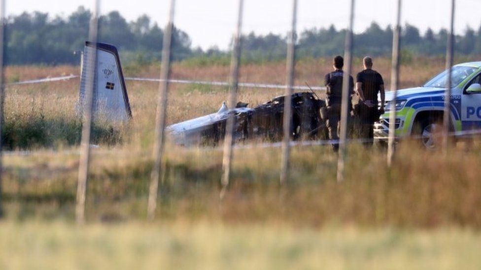 Police officers observe a small aircraft that crashed at Orebro Airport, Sweden