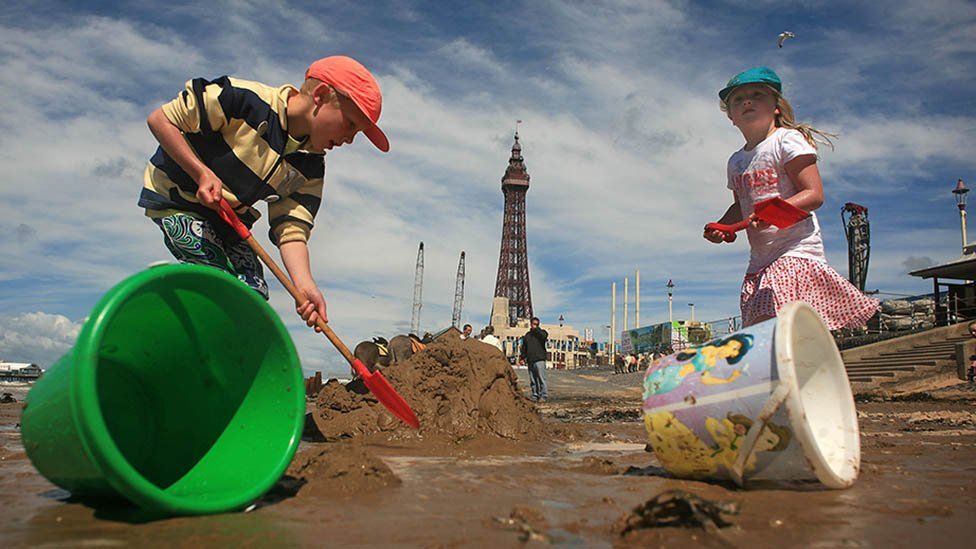 Kids play with buckets and spades on Blackpool beach