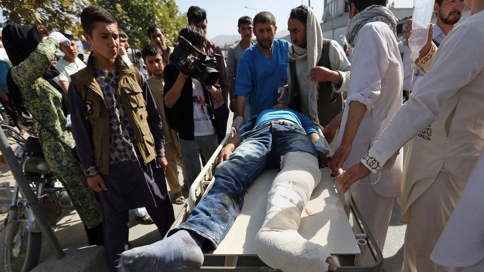 Afghans help an injured man at a hospital after an explosion struck a protest march, in Kabul, Afghanistan, Saturday, 23 July 2016.