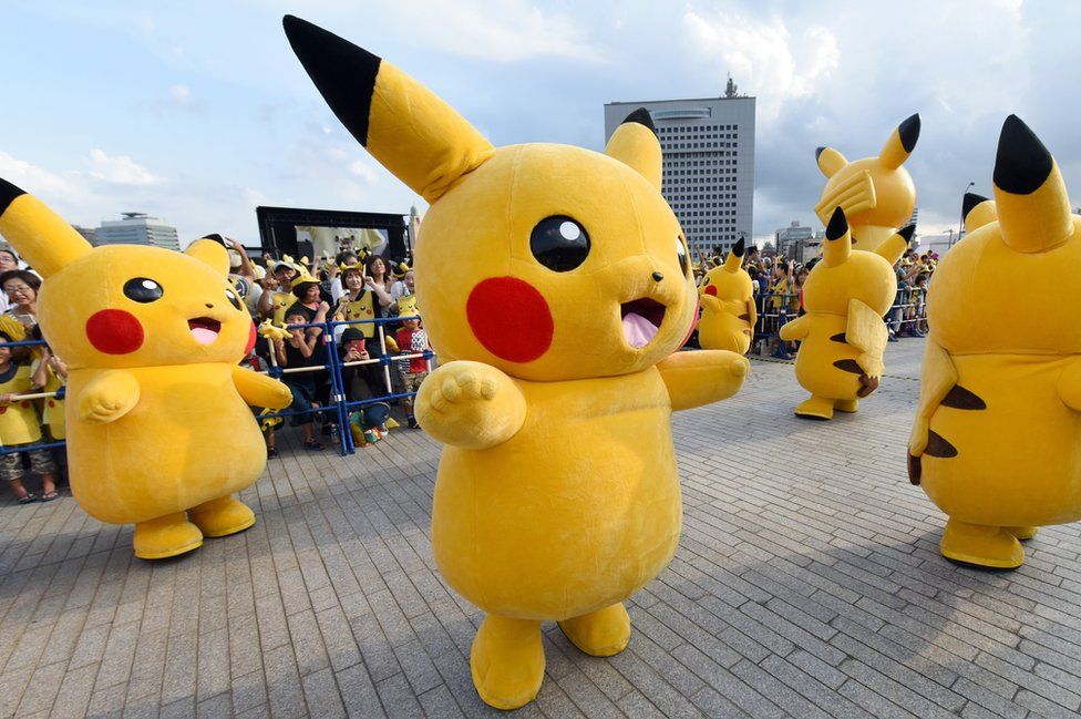 people in Pikachu costumes onstage in Japan