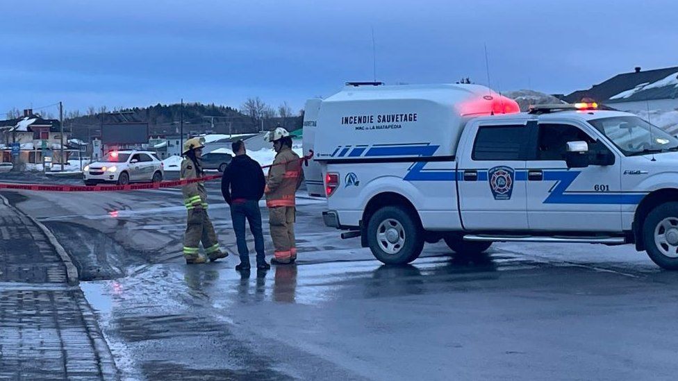 Firefighters stand near the site where a man ran down a group of pedestrians with a van in the in the Lower St. Lawrence region of Amqui, Quebec