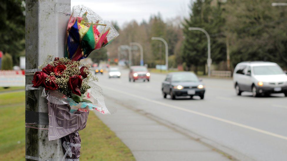 Flowers on lamppost marking scene of fatal accident