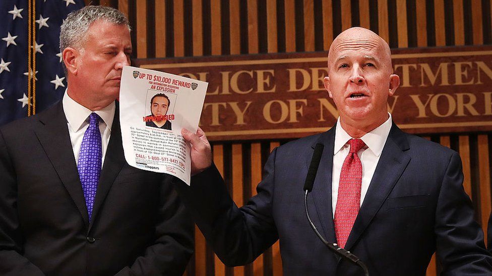 Начальник полиции Нью-Йорка Джеймс О'Нил показывает плакат с изображением подозреваемого как «задержанного»