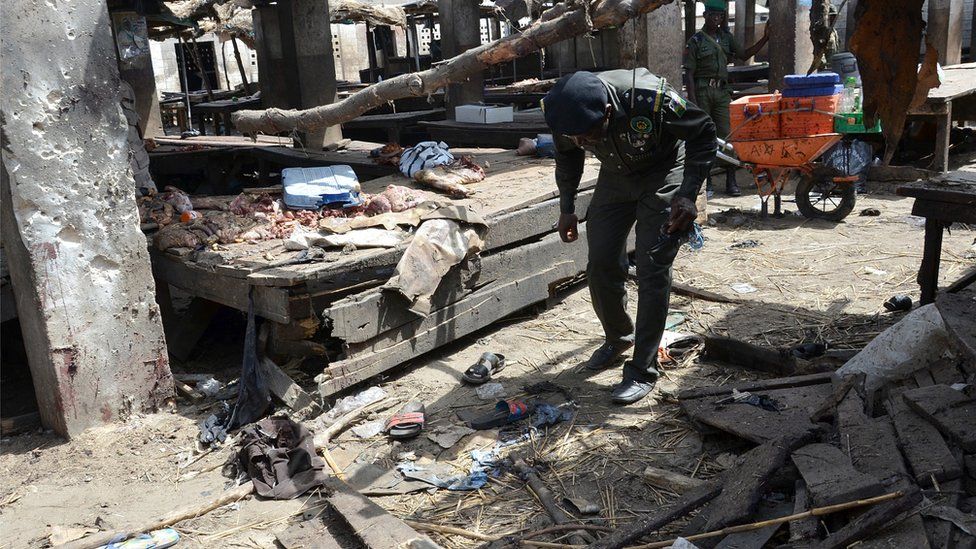 Nigerian policeman inspects the site of a suicide attack at a busy cattle market in the north-eastern Nigerian city of Maiduguri on June 2, 2015.