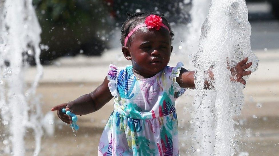 A little girl cools off in water fountains in Washington DC.