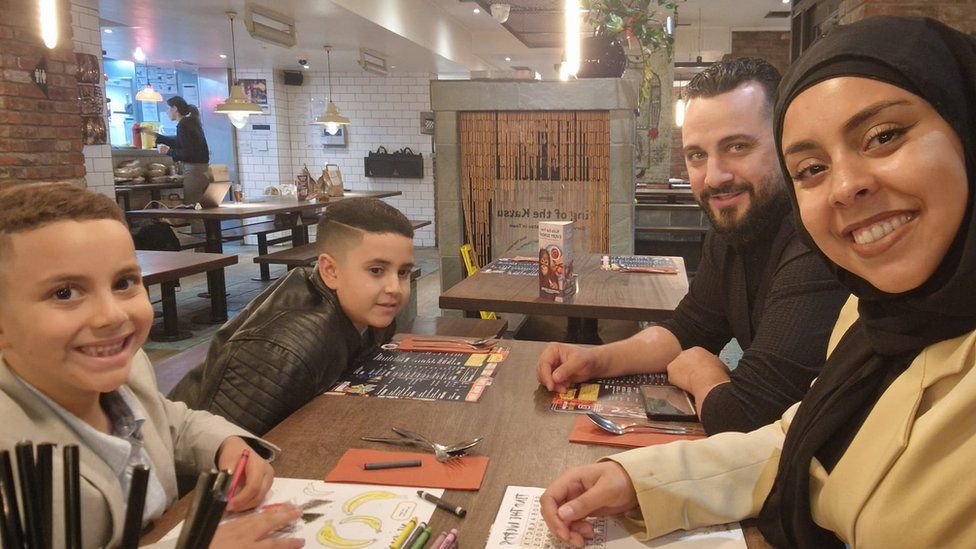 Soulaymane Mehmet and his younger brother, sitting with Mr and Mrs Mehmet at a restaurant table