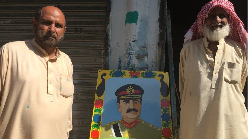 Truck art painter Habibur Rehman stands beside a painting of General Raheel Sharif
