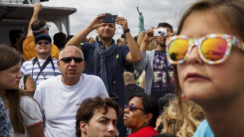 Visitors and tourists ride a ferry toward Liberty Island and the Statue of Liberty, August 8, 2017 in New York City.