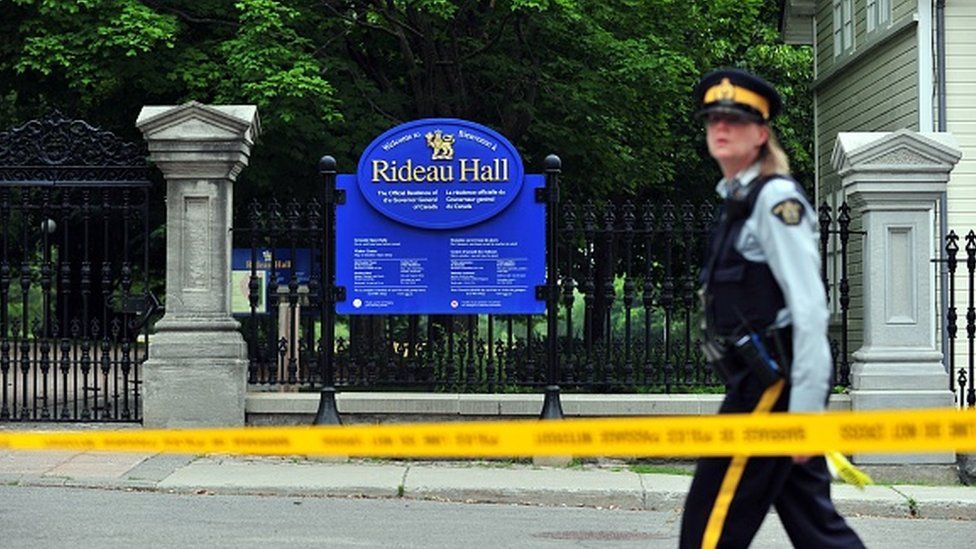 A Canadian police officer walks by Rideau Hall near the grounds of the Ottawa estate