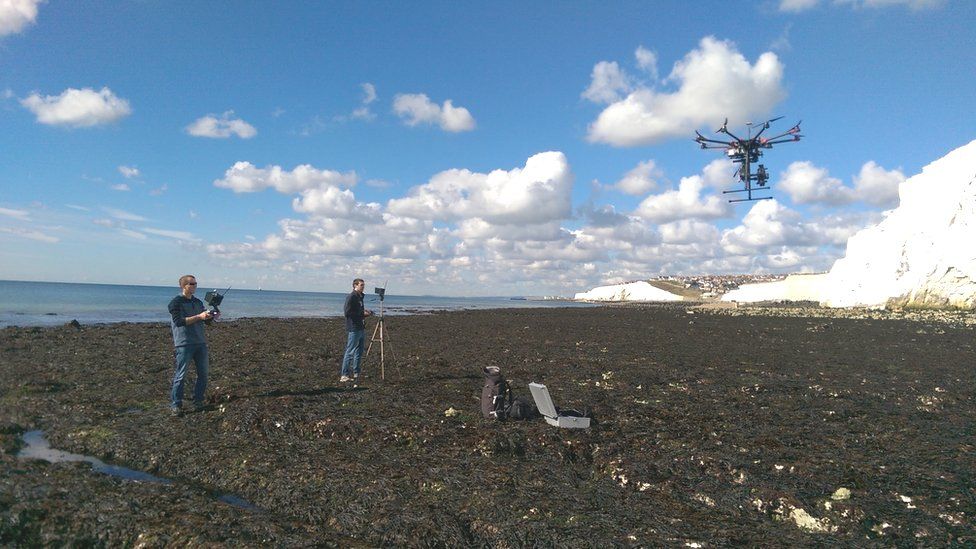 Dr Barlow (left) and Dr Jamie Gilham (right) launching a drone for sea cliff surveys