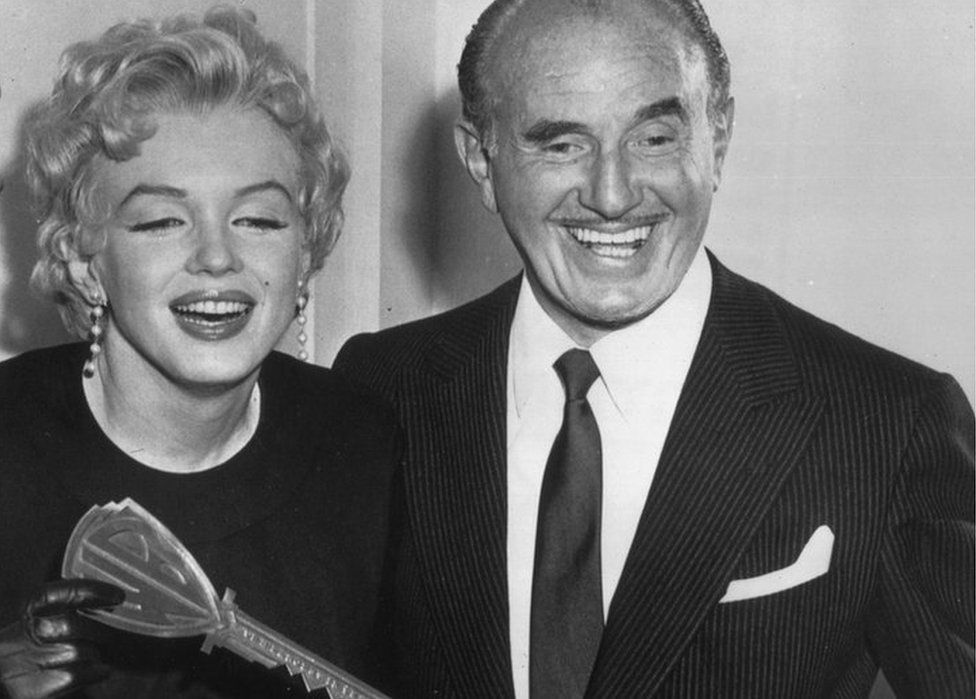 Marilyn Monroe being presented with the symbolic Warner Bros. key by Jack Warner, the studio's president in 1956