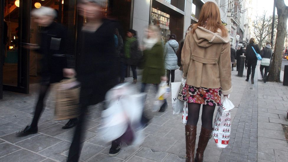 Woman in crowd in busy shopping street