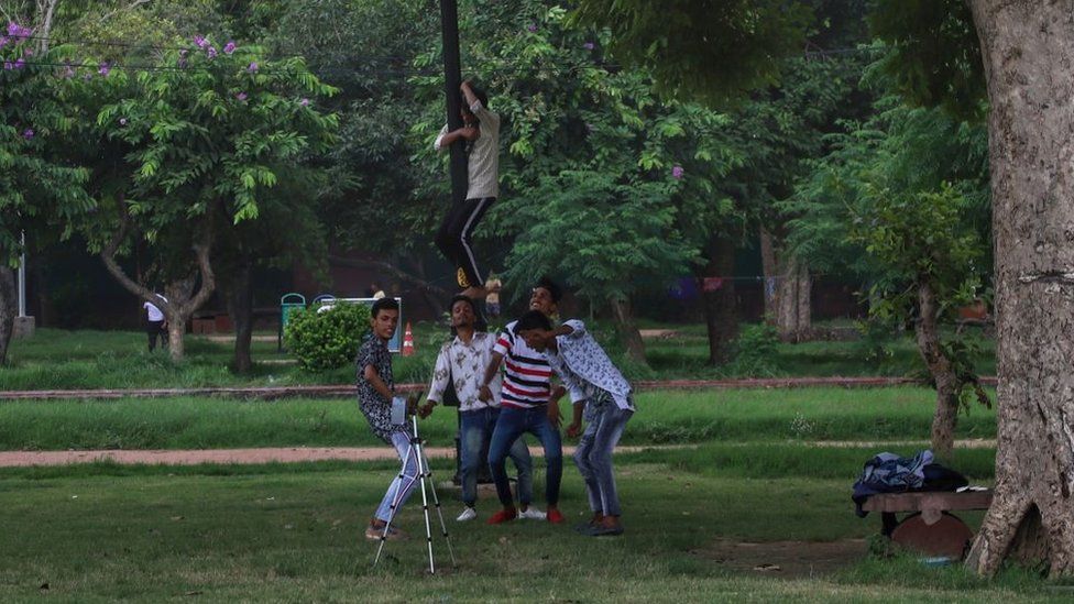 Young boys make videos for TIKTOK in a park in New Delhi