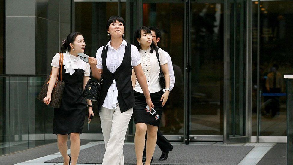 Businesswomen leave an office building in downtown Seoul, South Korea