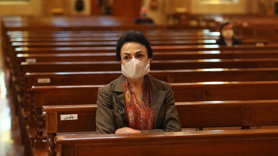 A woman sits in a church in Lebanon