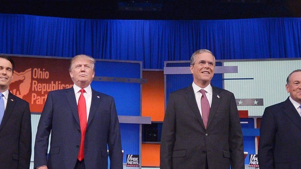 Republican presidential nominees Donald Trump and Jeb Bush stand on stage at a 2015 debate.