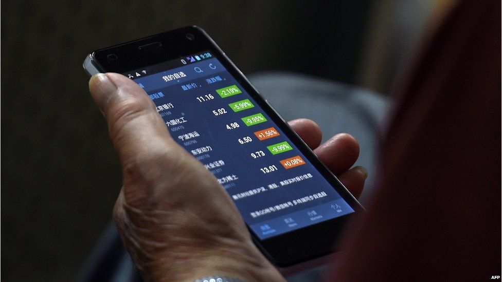 An investor checks stock prices on his smart phone at a securities company in Beijing on 9 July 2015.