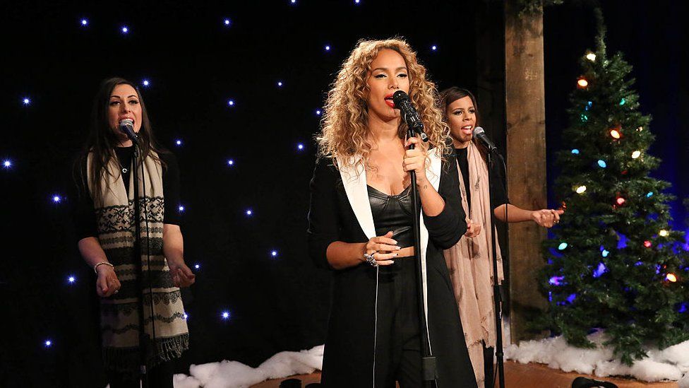 Leona Lewis singing with two back-up singers and a Christmas tree behind her