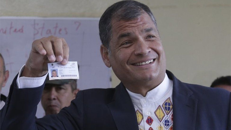 Ecuador's President Rafael Correa holds up his voter ID after casting his ballots in general elections in Quito, Ecuador, Sunday, Feb. 19, 2017.