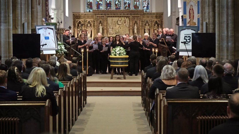 A choir singing around Barnaby's coffin