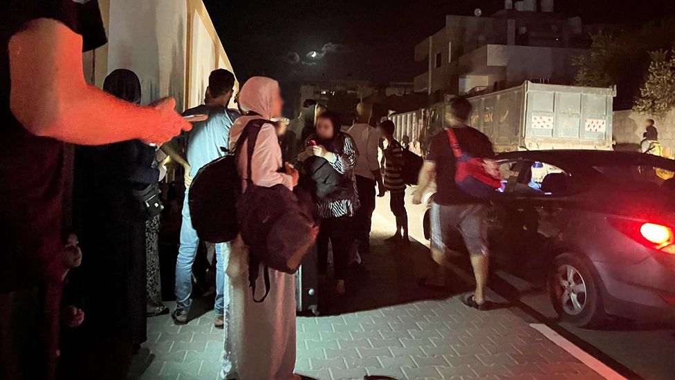 People waiting on the streets of Al-Zahra at night