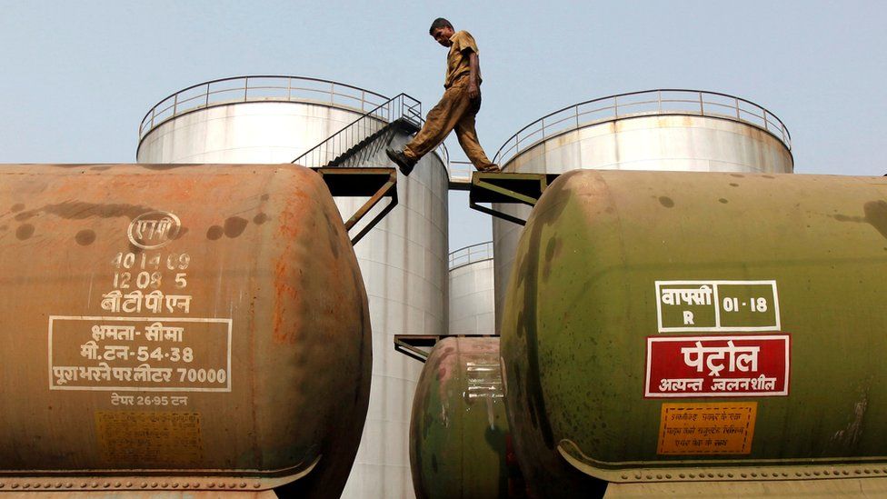 A worker walks apeak a tanker wagon at an oil terminal adjacent Kolkata.