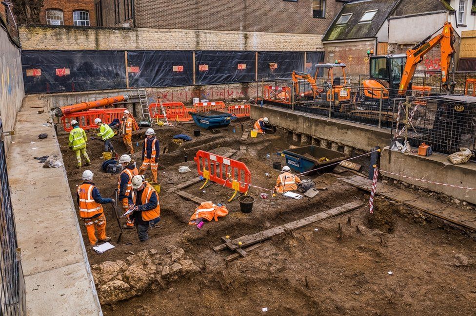 The archaeological team from Oxford Archaeology excavating pits on site in the east wing of the new basement.