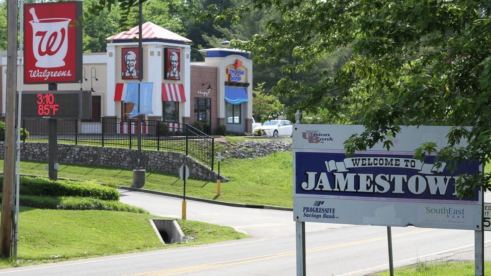 "Welcome to Jamestown" sign by the road, and main chains in the background: Walgreens and KFC