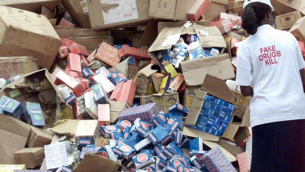 This file picture dated 13 October 2001 shows an official of the National Agency for Food and Drug Administration and Control (NAFDAC) off-loading cartoons of fake drugs for destruction 13 October 2001, at the premises of the agency in Lagos