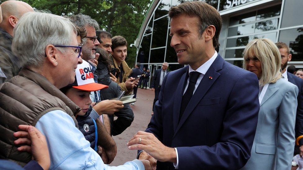 French President Emmanuel Macron greets supporters as he arrives to vote in the second round of French parliamentary elections, at a polling station in Le Touquet-Paris-Plage, France, June 19, 2022