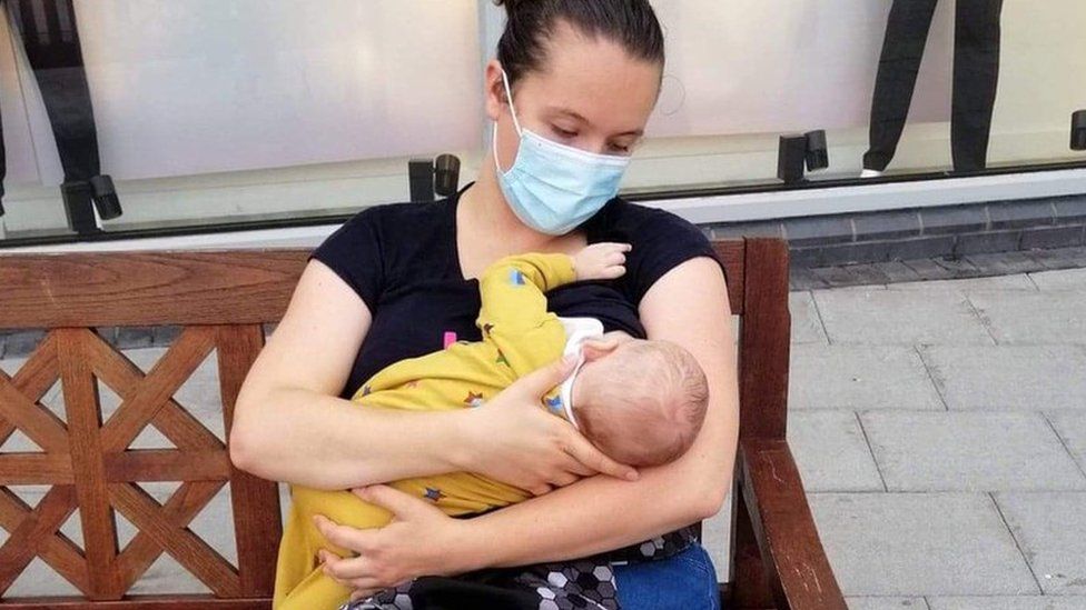 Richmal Eden feeding her baby in public while wearing a mask