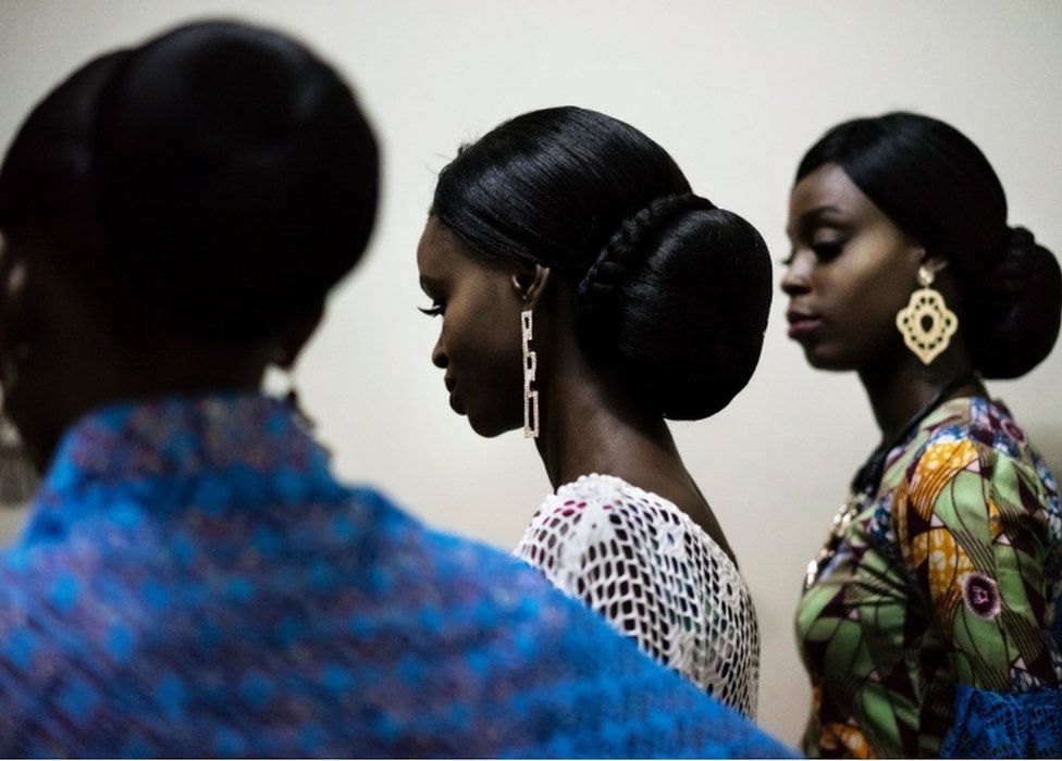 Models wait to enter the catwalk displaying creations of the Nigerian designer Nkem who is only 13 at the Africa Fashion Week in Lagos on June 3, 2017.