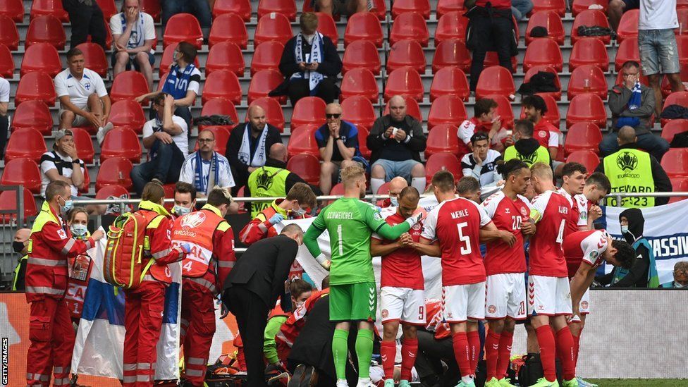 Denmark team-mates form a ring around the collapsed Christian Eriksen