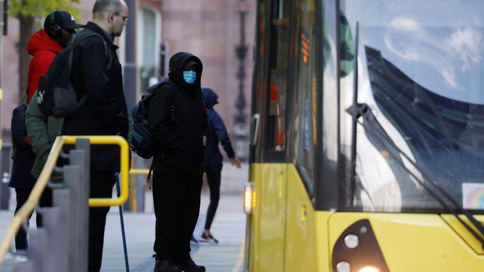Man in PPE boarding Manchester tram