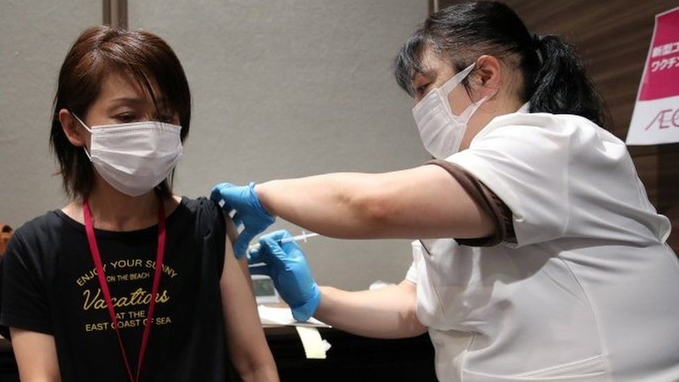 A staff of Japan's supermarket group Aeon receives a dose of the Moderna vaccine