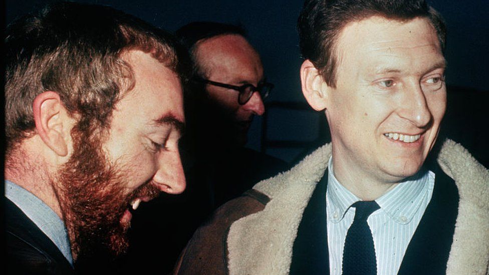 British journalist Anthony Grey (left), smiles upon arrival at London Airport from Karachi