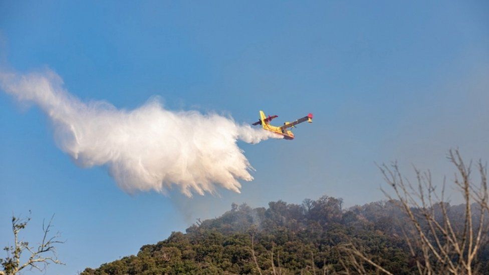 Самолет Canadair роняет воду на крупный лесной пожар, вспыхнувший в районе Вар на юге Франции