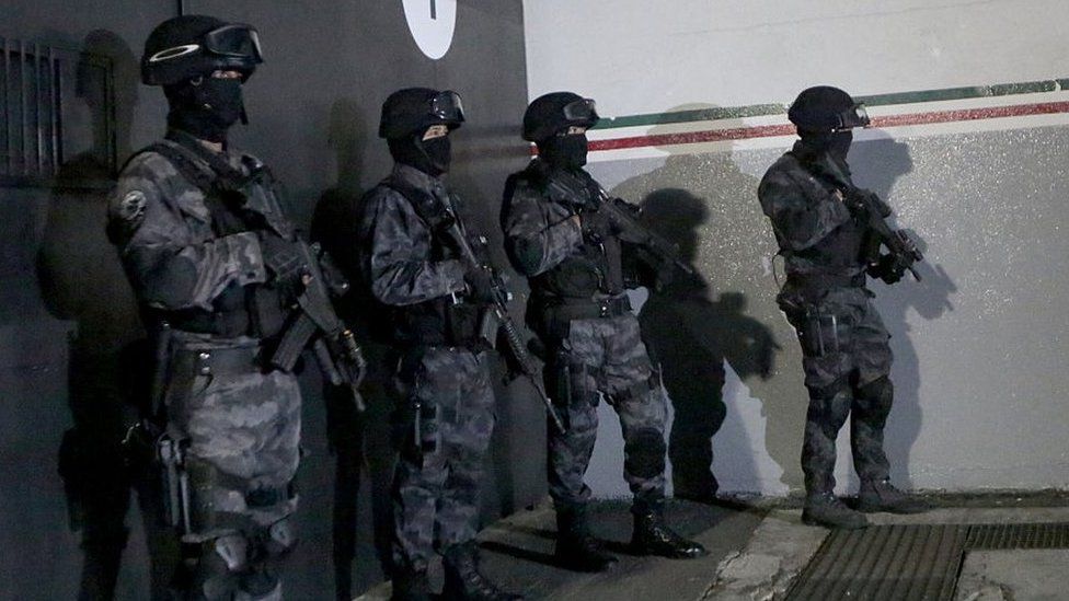 Police stand guard before the arrival of Hector "El Guero" Palma Salazar, member of the Sinaloa cartel at the international airport in Mexico City on June 15, 2016.
