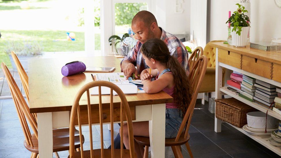 Father helping his daughter with homework