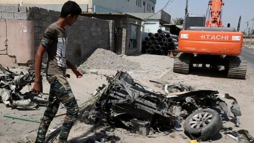 A man inspects the scene of an explosion in a busy commercial area in Baghdad (13 July)