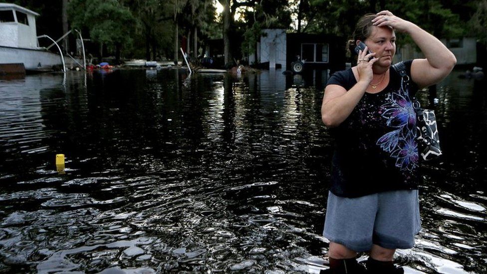 Lynne Garrett speaks to loved ones on the phone as she surveys damage outside of her home from the winds and storm surge associated with Hurricane Hermine which made landfall overnight in the area on 2 September 2016 in Tampa, Florida