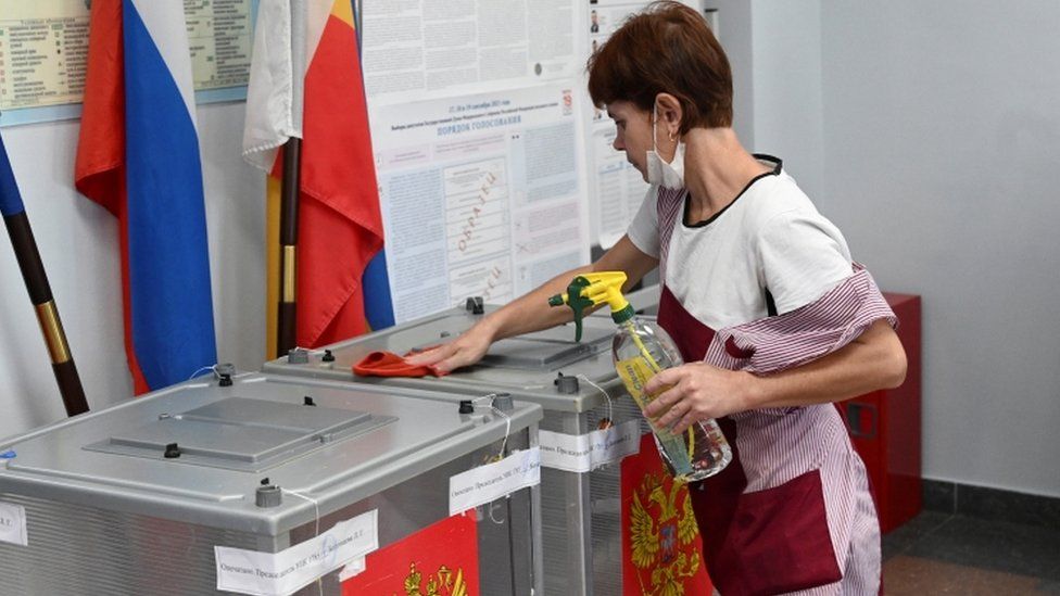 Специалист дезинфицирует урны для голосования на избирательном участке во время трехдневных парламентских выборов в Ростове-на-Дону, Россия 17 сентября 2021 г.