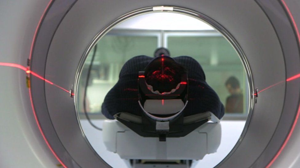 Someone getting their brain scanned in a PET scanner