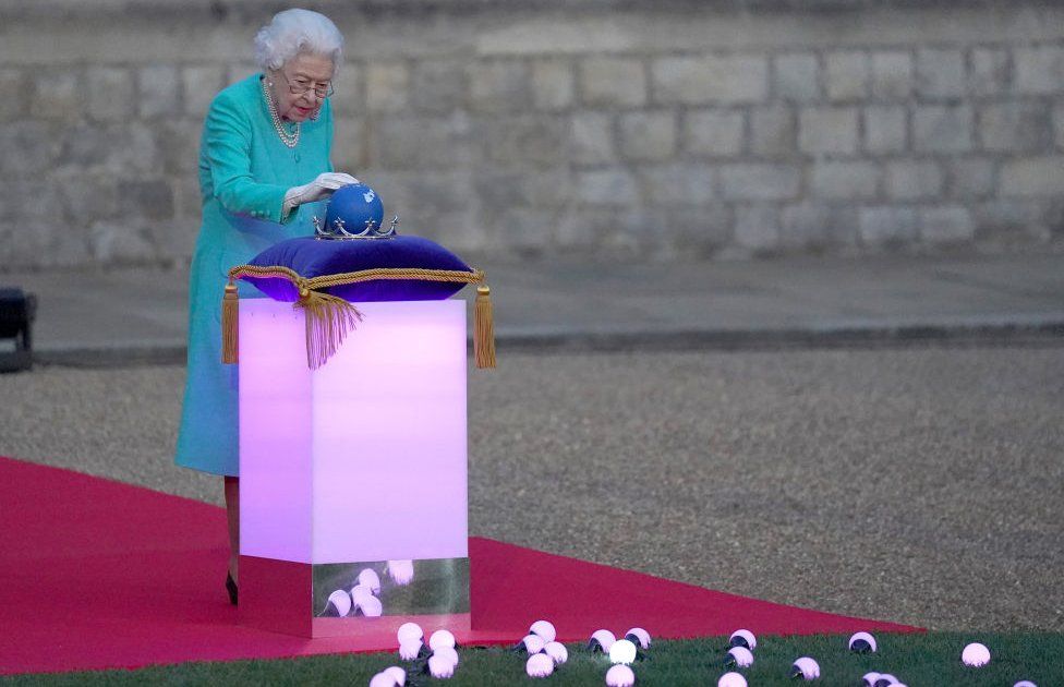 The Queen touches the Commonwealth Nations Globe to start the lighting of the Principal Beacon outside of Buckingham Palace in London, from the Quadrangle at Windsor Castle in Windsor, as part of Platinum Jubilee celebrations on 2 June 2022