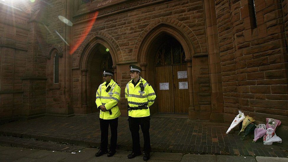 Police stand guard outside St Patrick's Church in Anderston, Glasgow