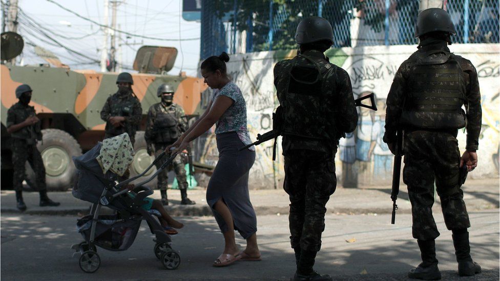 Brazilian soldiers carry out an operation in the Complexo do Alemao favela in Rio de Janeiro, 21 August 2018