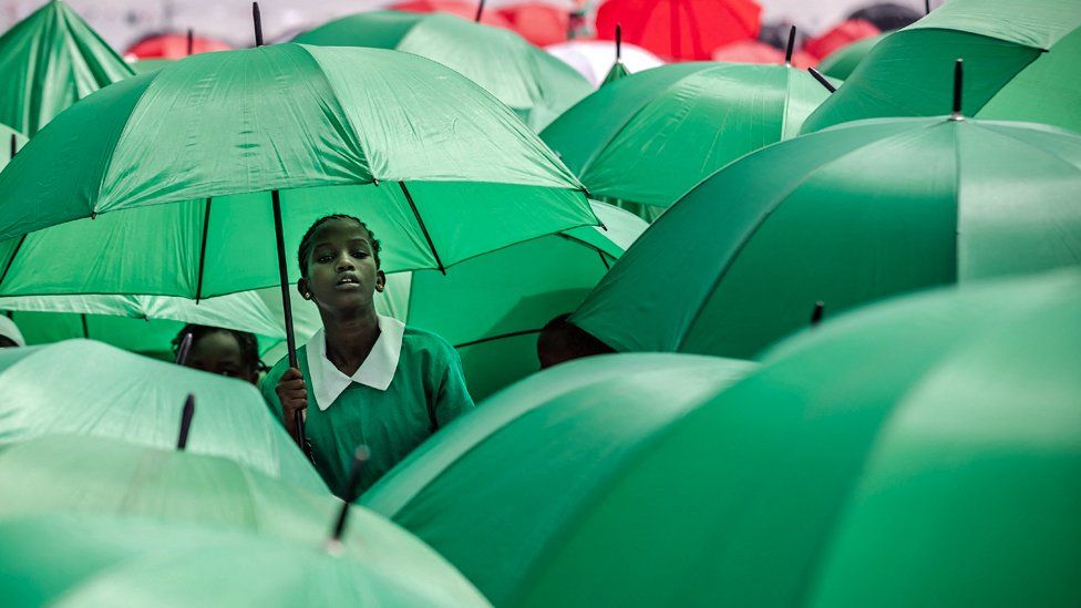 Kenyan students hold umbrellas to protect themselves from the sun during the celebrations of Kenya's 60th Independence Day, also known as Jamhuri Day, at the Uhuru Gardens in Nairobi, Kenya - Tuesday 12 December 2023