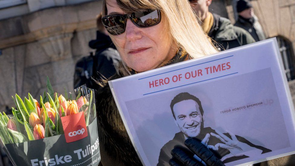 Protestors hold a picture of late Kremlin opposition leader Alexei Navalny reading 'hero of our times' in front of the Russian embassy in Copenhagen on March 17, 2024 during a presidential election in Russia
