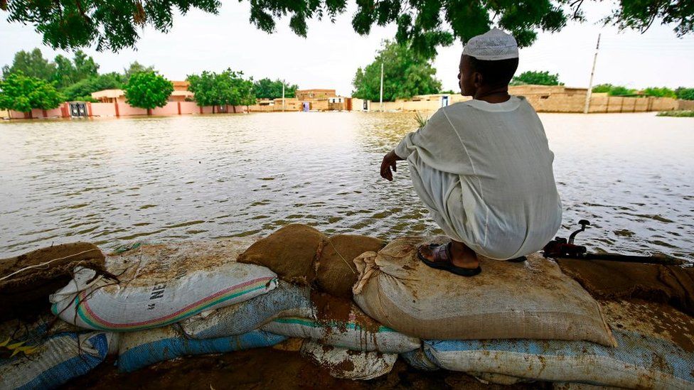 A Sudanese resident sits on flood barriers in the capital Khartoum's southern neighbourhood of al-Kalakla, on August 31, 2020.